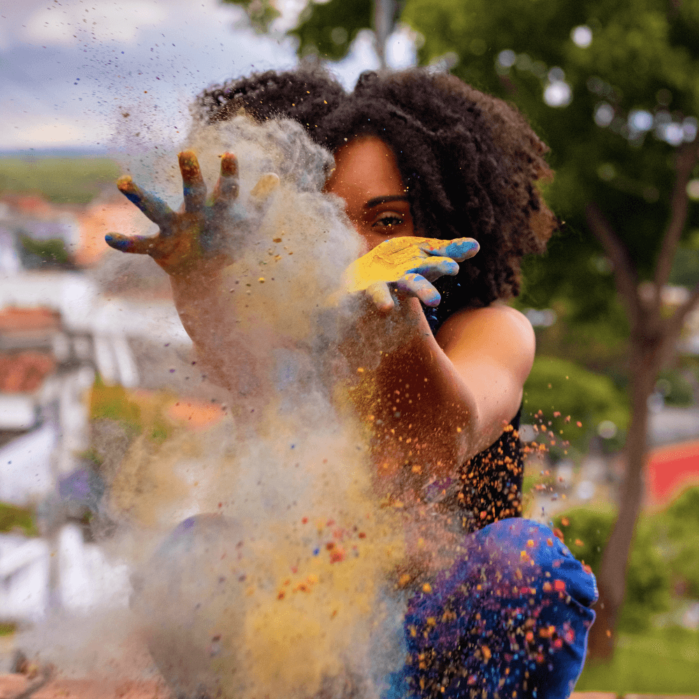 girl blowing colorful dust